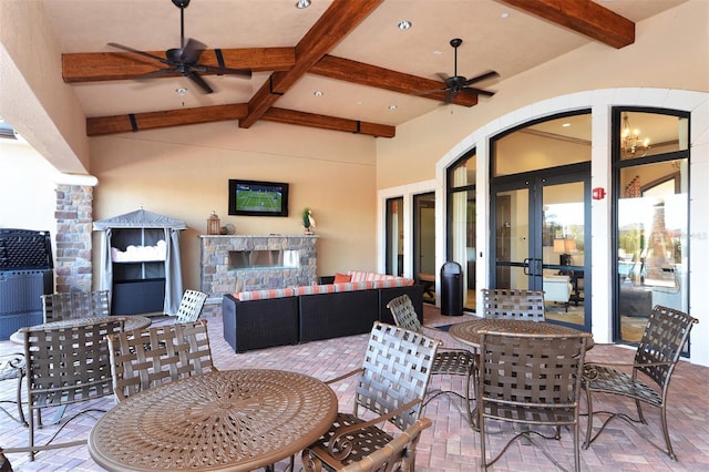 view of patio with an outdoor living space with a fireplace and ceiling fan