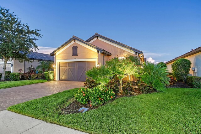 view of front of property with a garage and a lawn