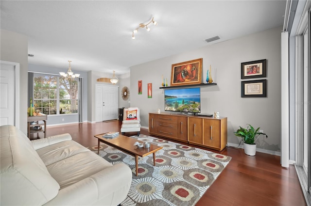 living room with a chandelier and dark hardwood / wood-style floors