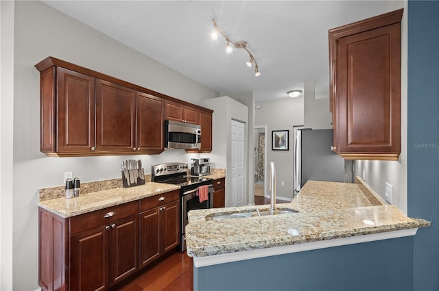 kitchen featuring appliances with stainless steel finishes, sink, dark hardwood / wood-style floors, and light stone counters