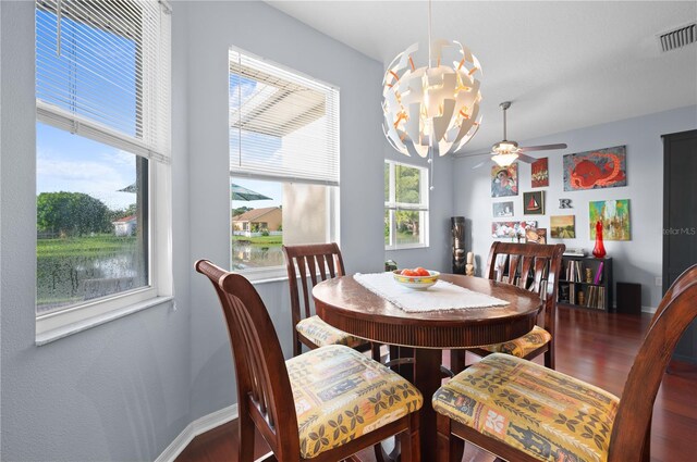 dining room featuring ceiling fan with notable chandelier and dark hardwood / wood-style floors