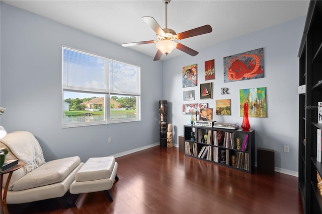 living area featuring ceiling fan and dark hardwood / wood-style flooring