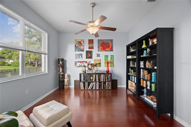 living area featuring dark hardwood / wood-style floors and ceiling fan