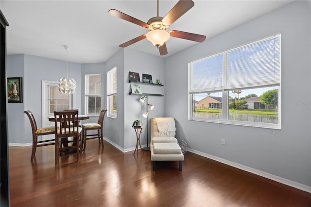 sitting room featuring ceiling fan with notable chandelier, plenty of natural light, and dark hardwood / wood-style flooring