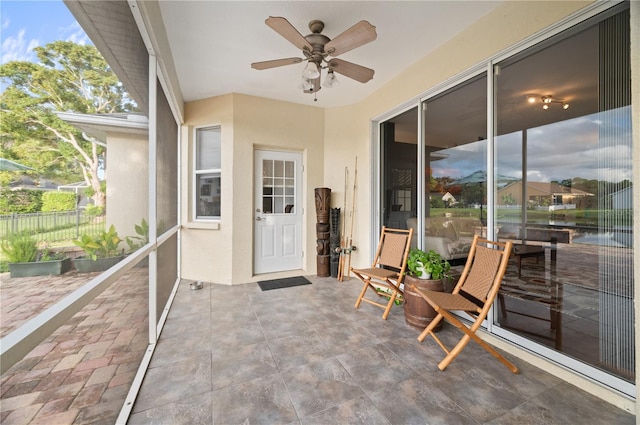 unfurnished sunroom featuring ceiling fan