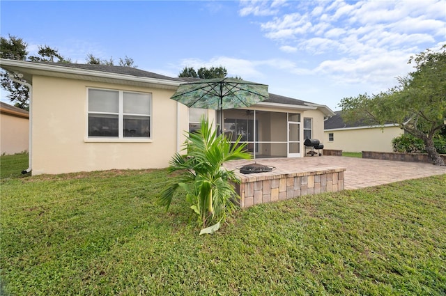 rear view of house featuring a fire pit, a sunroom, a yard, and a patio