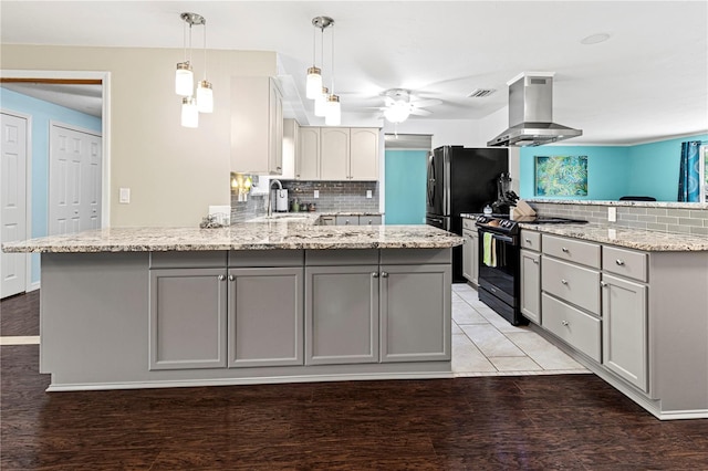 kitchen featuring ventilation hood, kitchen peninsula, black range with electric cooktop, and hardwood / wood-style floors