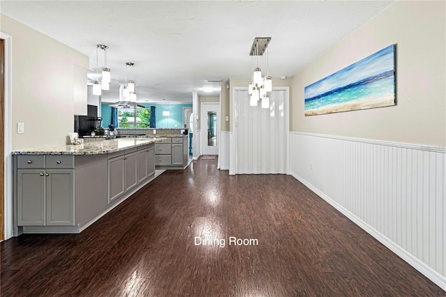 kitchen featuring gray cabinetry, dark wood-type flooring, and decorative light fixtures