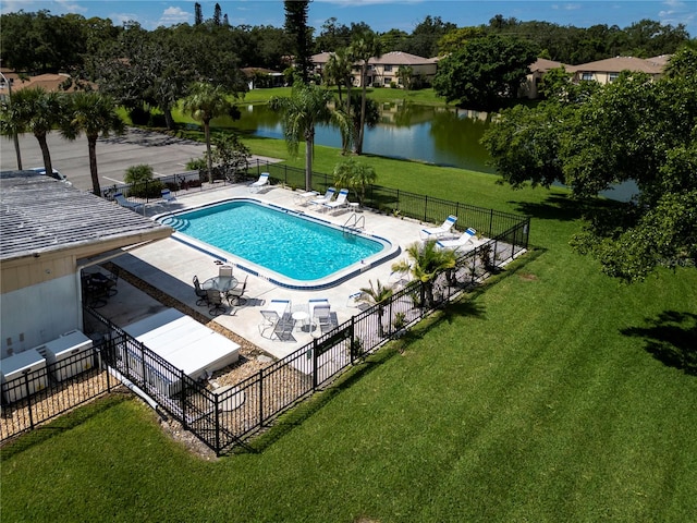 view of swimming pool with a lawn, a water view, and a patio area