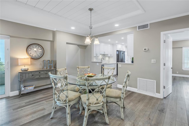 dining room featuring light wood-type flooring, wood ceiling, and a tray ceiling