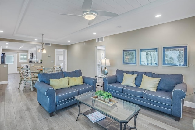 living room with light hardwood / wood-style flooring and ceiling fan