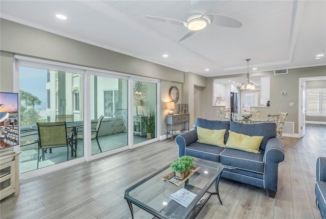 living room featuring wood-type flooring and ceiling fan with notable chandelier