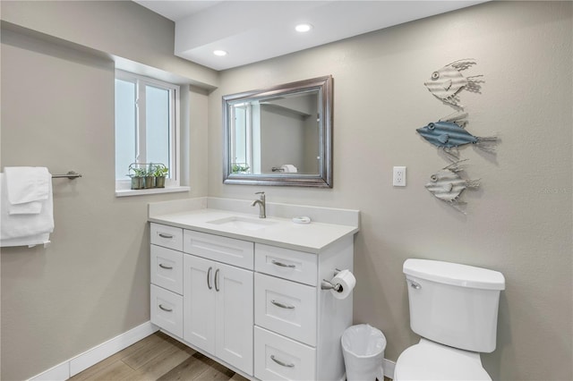 bathroom featuring wood-type flooring, vanity, and toilet