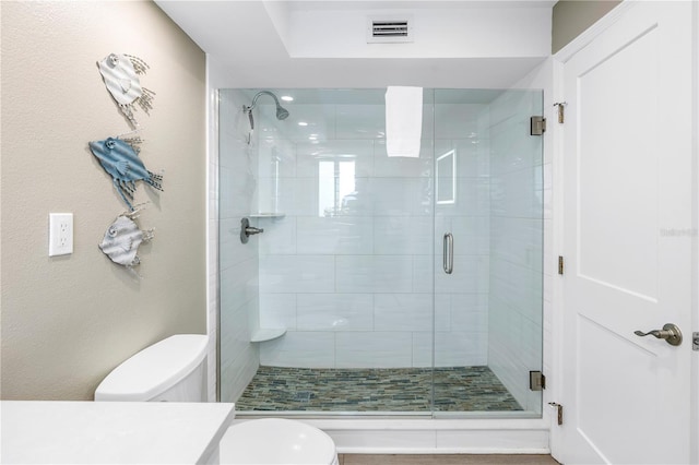 bathroom with walk in shower, vanity, and toilet