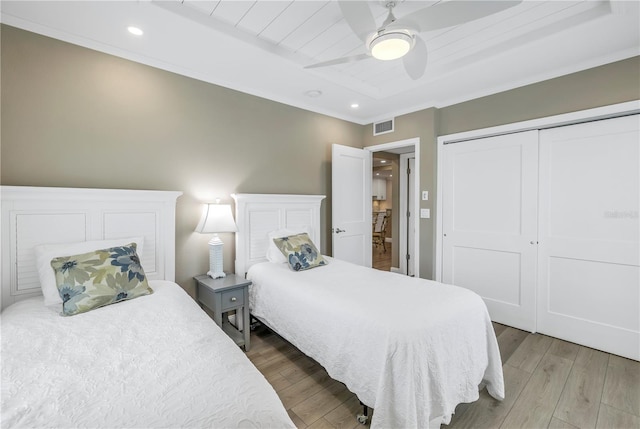 bedroom with wood-type flooring, ceiling fan, and a closet