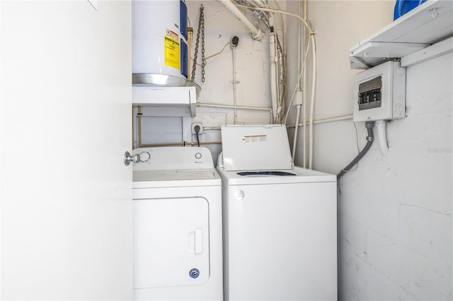 clothes washing area featuring water heater and washing machine and clothes dryer