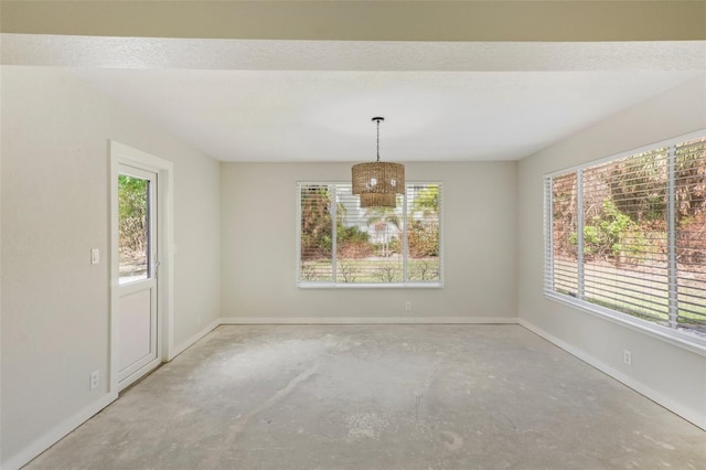 empty room with a wealth of natural light, concrete flooring, and a textured ceiling