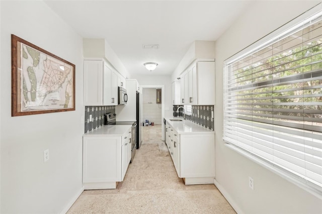 kitchen featuring white cabinets, sink, stainless steel appliances, and tasteful backsplash