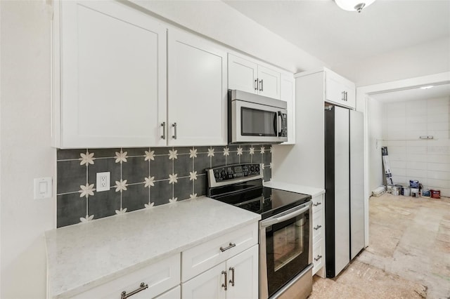 kitchen featuring white cabinets, appliances with stainless steel finishes, and tasteful backsplash