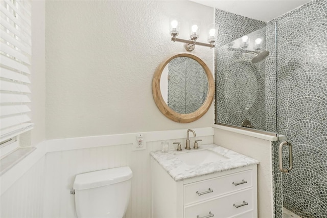 bathroom with walk in shower, vanity, and toilet