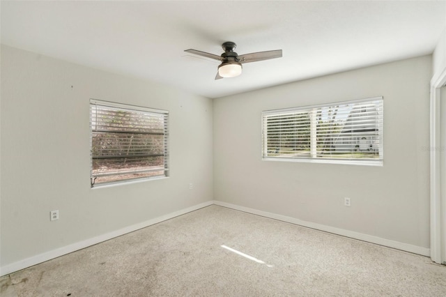 spare room featuring light colored carpet and ceiling fan