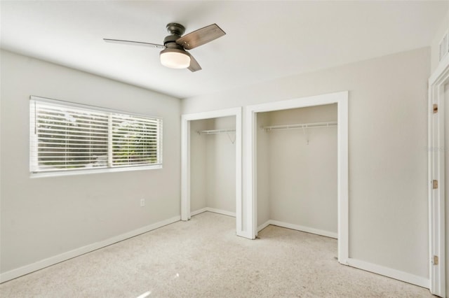 unfurnished bedroom featuring multiple closets, ceiling fan, and light carpet