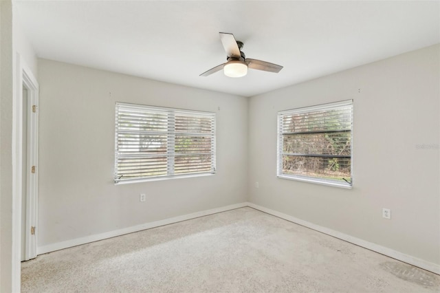 empty room featuring ceiling fan, light colored carpet, and a healthy amount of sunlight