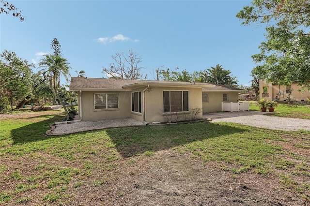 rear view of house featuring a yard