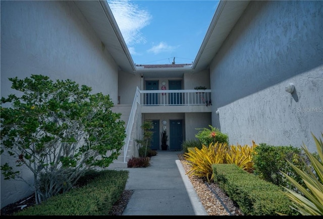 view of exterior entry with a balcony