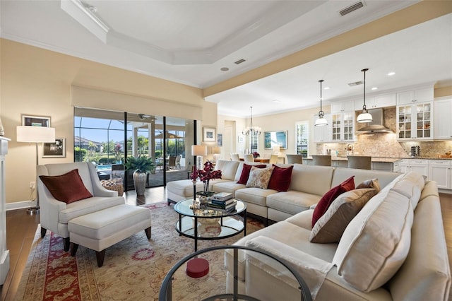 living room featuring ornamental molding, a chandelier, and hardwood / wood-style flooring