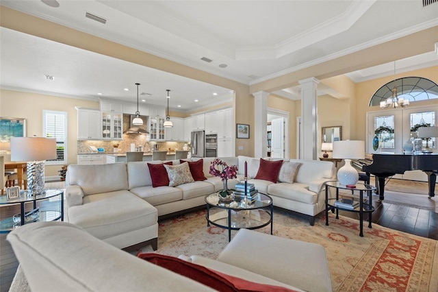 living room with ornamental molding, decorative columns, and light hardwood / wood-style floors