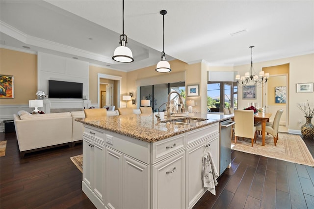 kitchen with hanging light fixtures, light stone countertops, and dark wood-type flooring