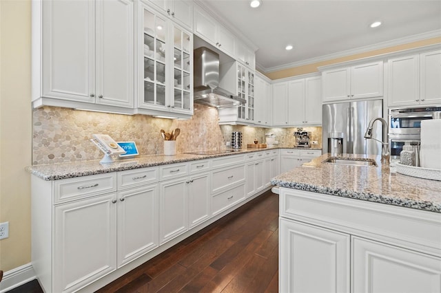 kitchen with wall chimney exhaust hood, ornamental molding, dark hardwood / wood-style flooring, and white cabinets