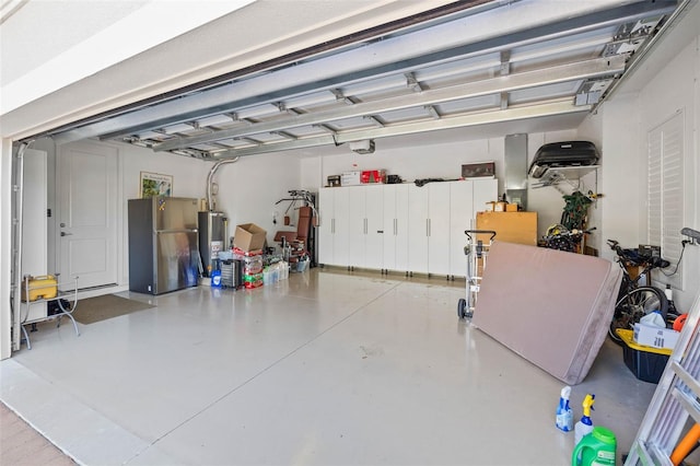 garage with a garage door opener, water heater, and stainless steel fridge