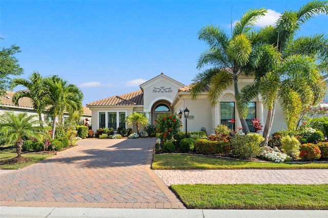 mediterranean / spanish home featuring decorative driveway and stucco siding