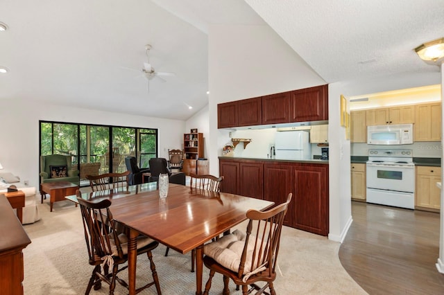 dining space featuring light wood-style floors, high vaulted ceiling, and ceiling fan