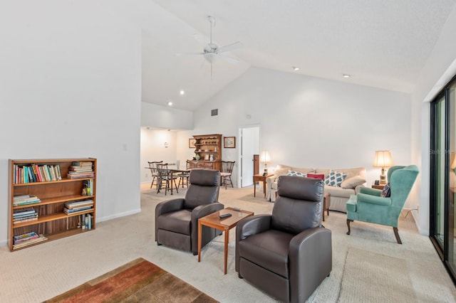 carpeted living room with ceiling fan and high vaulted ceiling