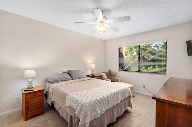 carpeted bedroom featuring ceiling fan and a textured ceiling