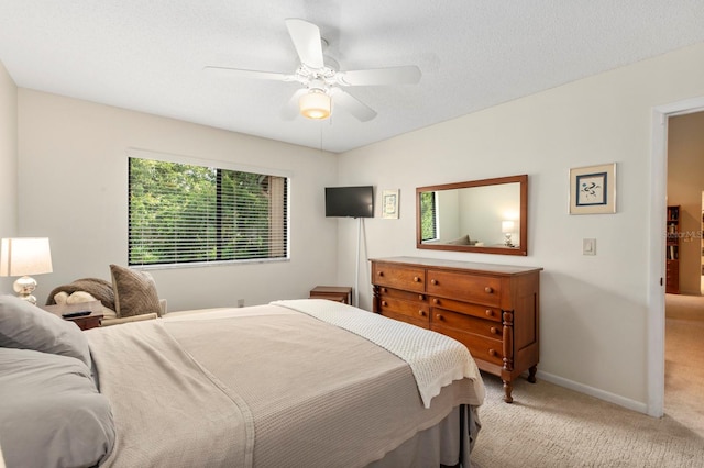 carpeted bedroom with ceiling fan and a textured ceiling