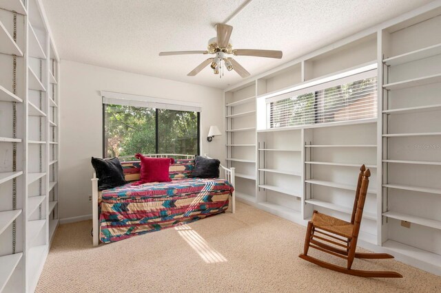 bedroom featuring ceiling fan, a textured ceiling, and carpet floors