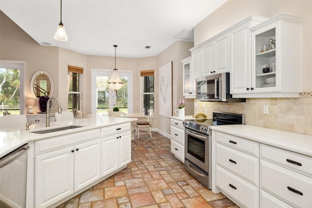 kitchen with white cabinets, stainless steel appliances, sink, and a wealth of natural light