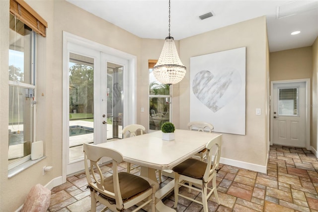 dining space with french doors and a notable chandelier