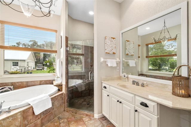 bathroom with vanity, a chandelier, and plus walk in shower