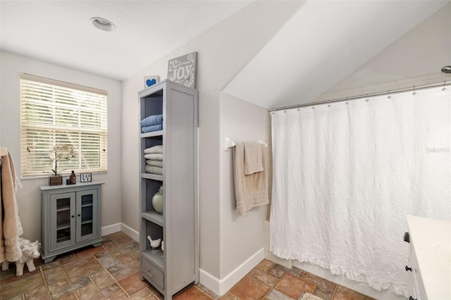 bathroom with vanity, curtained shower, and vaulted ceiling