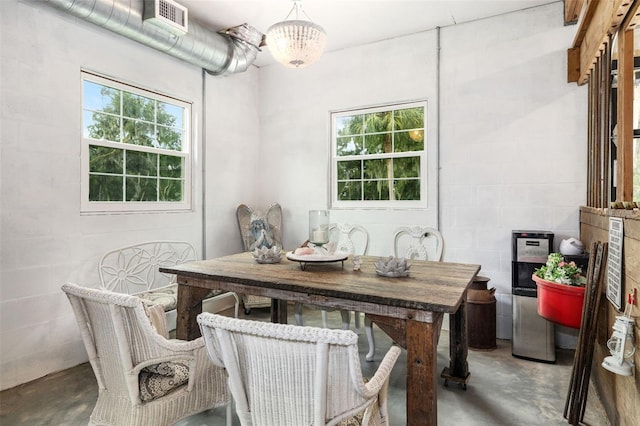 dining area with an inviting chandelier and concrete flooring