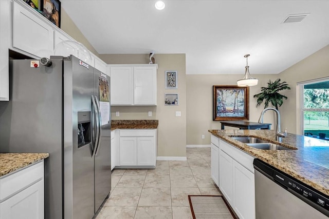 kitchen featuring white cabinets, lofted ceiling, sink, decorative light fixtures, and appliances with stainless steel finishes