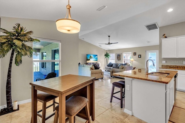 kitchen with sink, an island with sink, lofted ceiling, white cabinetry, and ceiling fan