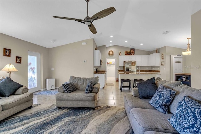 living room with ceiling fan, lofted ceiling, and light tile patterned floors