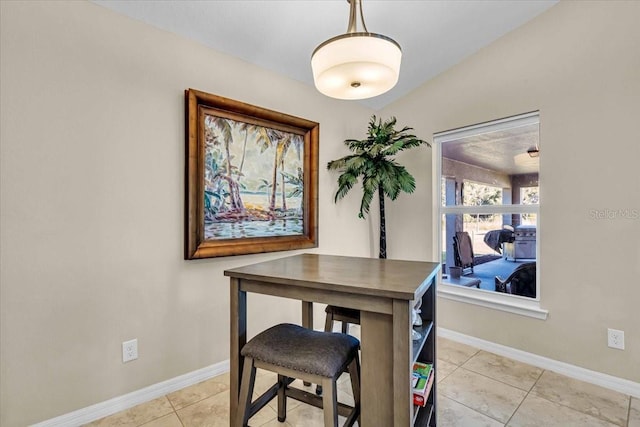 dining area featuring lofted ceiling and light tile patterned floors