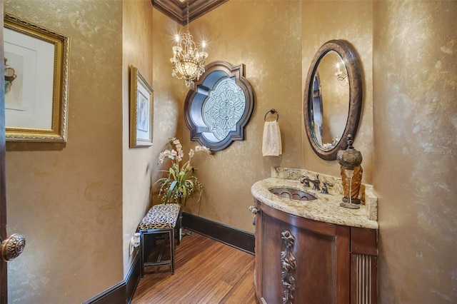 bathroom with hardwood / wood-style flooring, vanity, and crown molding